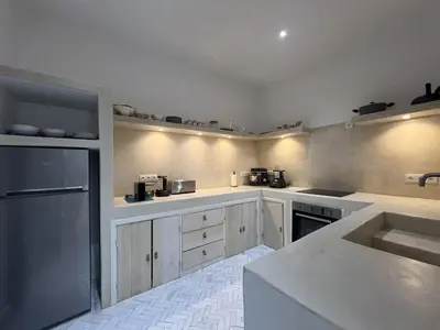 a kitchen with white cabinets and a black refrigerator at Riad Manoury Marrakech - privates Boutique-Hotel für 6 in Marrakech