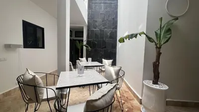 a dining room with tables and chairs and a potted plant at Riad Manoury Marrakech - privates Boutique-Hotel für 6 in Marrakech
