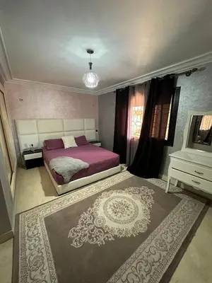a bedroom with a large bed and a television at Riad Arfoud Duplex Fully Equiped in Marrakech