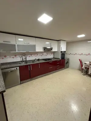 a large kitchen with red and white cabinets and appliances at Riad Arfoud Duplex Fully Equiped in Marrakech