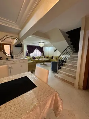 a kitchen and a living room with a staircase at Riad Arfoud Duplex Fully Equiped in Marrakech