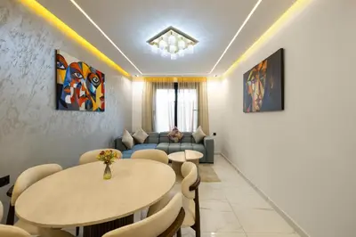 a living room with two tables and a couch at Moderne appart Gueliz 3 ch parking Carrefour in Marrakech