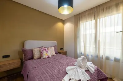 a bedroom with a purple bed and a window at Moderne appart Gueliz 3 ch parking Carrefour in Marrakech