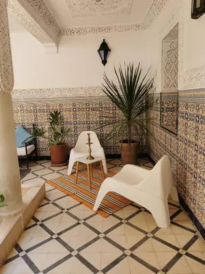 a room with two white chairs and a tiled floor at Dar Ahlam in Marrakech