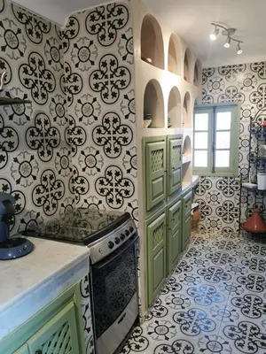 a kitchen with green cabinets and a stove at Dar Ahlam in Marrakech