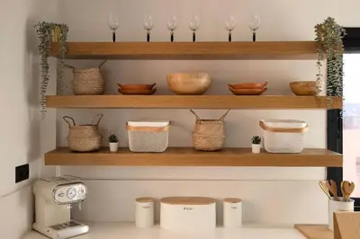 a kitchen with wooden shelves with bowls and baskets at Majorelle Garden Gem in Marrakech