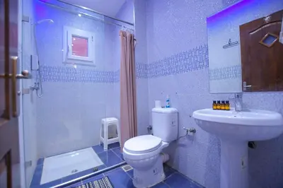 a bathroom with a toilet and a sink and a shower at Appartement calme avec piscine et parking in Marrakech