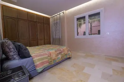 a bedroom with a bed and a window at Appartement calme avec piscine et parking in Marrakech