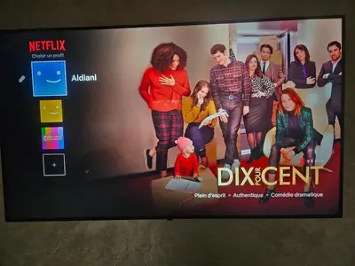 a tv screen with a picture of a group of people at Appartement calme avec piscine et parking in Marrakech