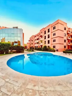 a large swimming pool in front of a building at Appartement calme avec piscine et parking in Marrakech