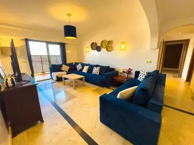 a living room with blue couches and a flat screen tv at Gueliz 2-BR Apt Pool, Close to Majorelle Garden in Marrakech