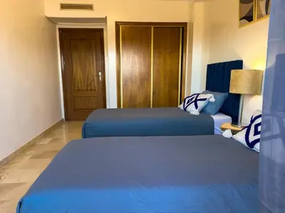 two beds in a hotel room with blue sheets at Gueliz 2-BR Apt Pool, Close to Majorelle Garden in Marrakech