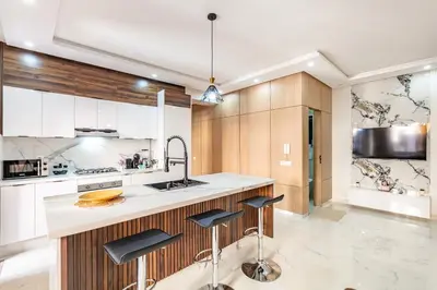 a kitchen with white cabinets and a counter with stools at comfortable equipped apartment in Marrakech