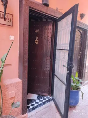an entrance to a house with a wooden door at Riad Zellige 95 in Marrakech