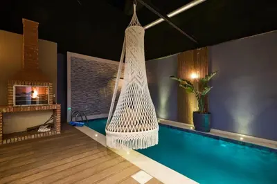 a hammock hanging in a room with a swimming pool at luxueux duplex avec piscine privée in Marrakech