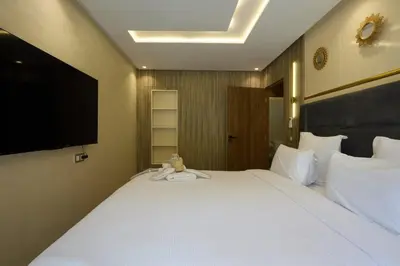 a large white bed with a teddy bear sitting on it at luxueux duplex avec piscine privée in Marrakech