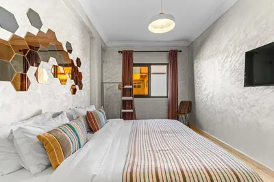 a bedroom with a bed and a tv on the wall at Massira Social Living in Marrakech