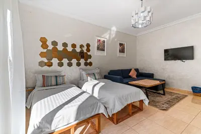 a bedroom with two beds and a blue couch at Massira Social Living in Marrakech
