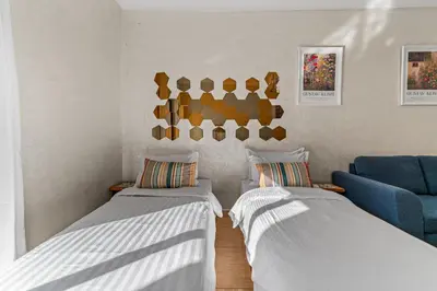 a room with two beds and a blue couch at Massira Social Living in Marrakech