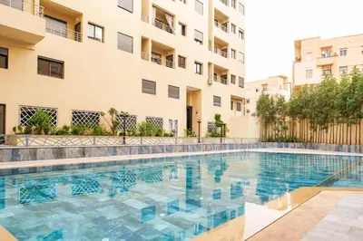 a swimming pool in front of a building at family pool apartment in Marrakech