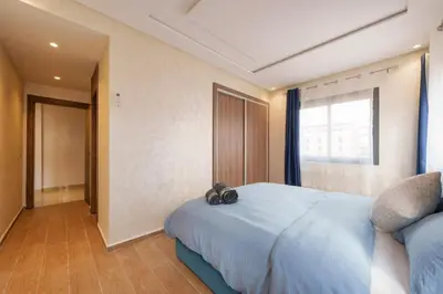 a bedroom with a blue bed with a large window at family pool apartment in Marrakech
