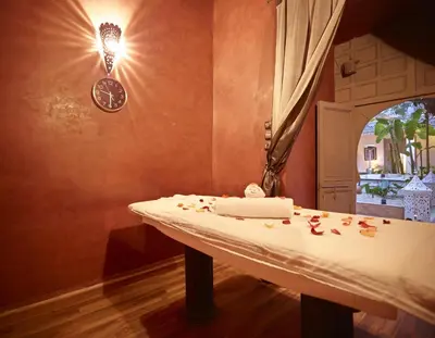 a bathroom with a table with a clock on the wall at Riad Les Jardins d'Henia in Marrakech
