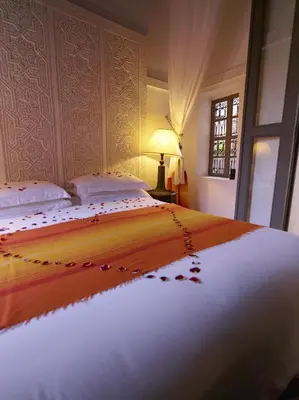 a bedroom with a large bed with flowers on it at Riad Les Jardins d'Henia in Marrakech