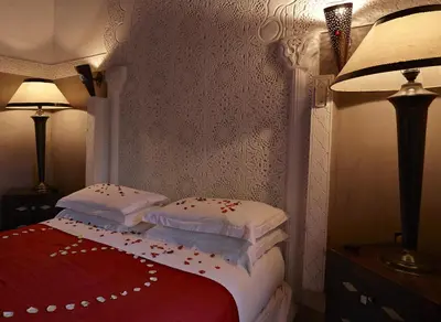 a bedroom with a bed with pillows on it at Riad Les Jardins d'Henia in Marrakech