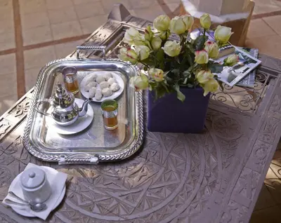 a tray of food and a vase of flowers on a table at Riad Les Jardins d'Henia in Marrakech