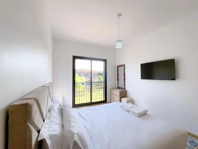 a white bedroom with a bed and a window at Noria Golf Elegance Pool with View in Marrakech