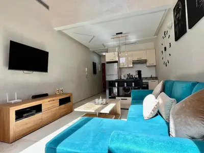a living room with a blue couch and a tv at Beautiful Duplex Fast Wi-Fi Terrace Pool in Marrakech