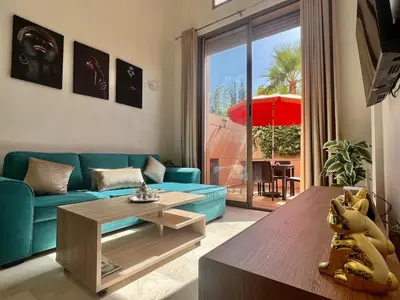 a living room with a blue couch and a table at Beautiful Duplex Fast Wi-Fi Terrace Pool in Marrakech