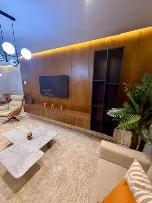 a living room with a tv and a couch and a table at Le Nid Hermès in Marrakech