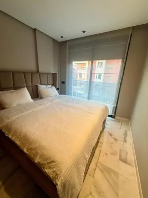 a large bed in a room with a large window at Le Nid Hermès in Marrakech