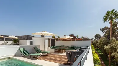 an outdoor patio with chairs and a swimming pool at Dar 118, 3ch, hammam, piscine, rooftop, personnel in Marrakech