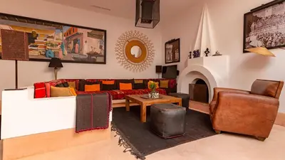 a living room with a couch and a table at Dar 118, 3ch, hammam, piscine, rooftop, personnel in Marrakech