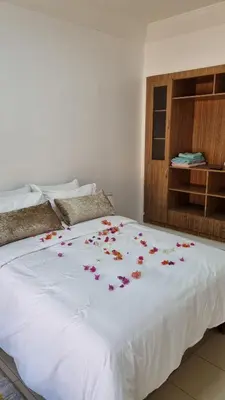 a white bed with flowers on top of it at Happy Relaxing home in Marrakech