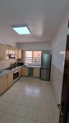 a large kitchen with a refrigerator and a tile floor at Happy Relaxing home in Marrakech