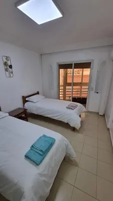 a hotel room with two beds and a window at Happy Relaxing home in Marrakech