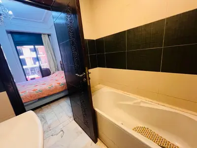 a bathroom with a tub and a bed in a window at Résidence belle vie 6 avec piscine in Marrakech
