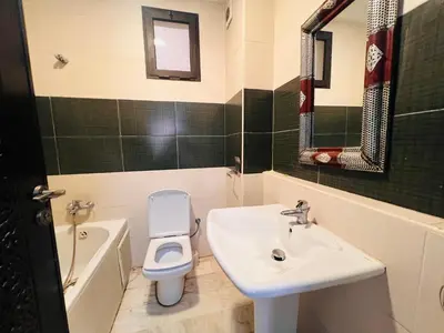 a bathroom with a sink and a toilet and a tub at Résidence belle vie 6 avec piscine in Marrakech