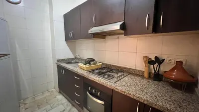 a small kitchen with a stove and a sink at Résidence belle vie 6 avec piscine in Marrakech