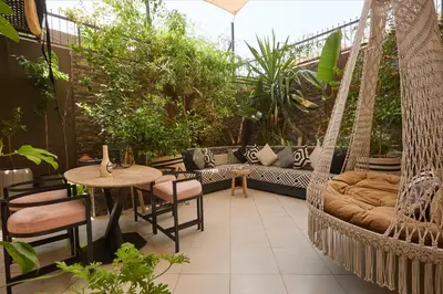 a patio with a hammock and a table and chairs at Super duplexe en plein Marrakech in Marrakech