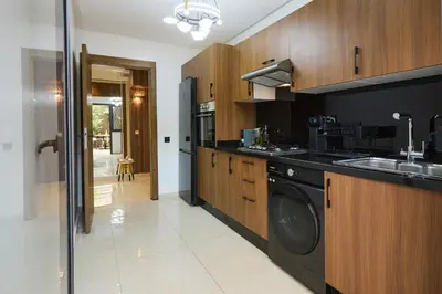 a kitchen with wooden cabinets and a washer and dryer at Super duplexe en plein Marrakech in Marrakech