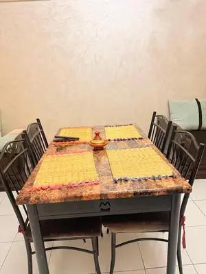 a table with chairs and a table with a quilt on it at Apartment in the heart of Gueliz in Marrakech