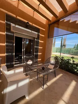 a patio with two chairs and a table and a window at Villa Sofia And Spa in Marrakech