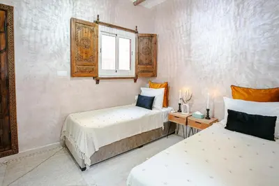 a bedroom with two beds and a window at Riad 3ch, proche Médina, résidence avec piscines in Marrakech