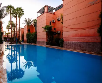a large blue swimming pool next to a building at Riad 3ch, proche Médina, résidence avec piscines in Marrakech