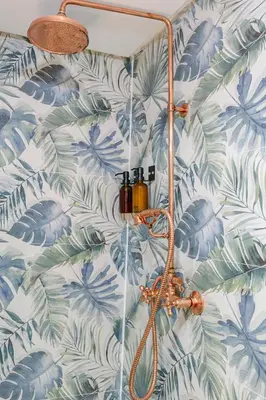 a bathroom with a blue and green leafy wall at Riad 3ch, proche Médina, résidence avec piscines in Marrakech