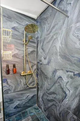 a shower in a bathroom with a marble wall at Riad 3ch, proche Médina, résidence avec piscines in Marrakech